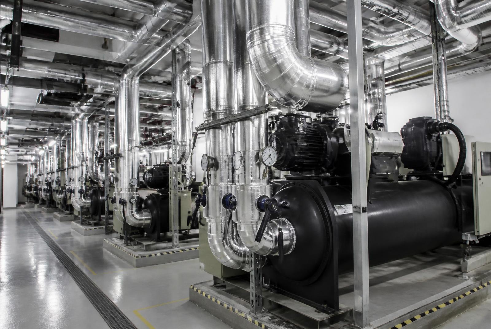 Industrial chiller plant with insulated chilled-water piping and mechanical cooling equipment.
